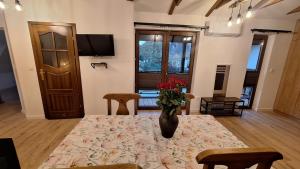 a dining room with a table with a vase of flowers on it at Domek Julia in Krościenko