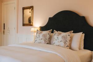 a bedroom with a bed with a black headboard and pillows at Mossie's in Adrigole