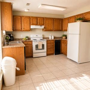 a kitchen with wooden cabinets and a white refrigerator at The Calm Cove - Near shopping and entertainment in Osage Beach