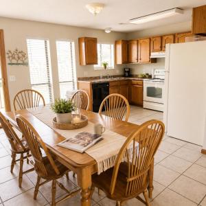 a kitchen with a wooden table with chairs and a refrigerator at The Calm Cove - Near shopping and entertainment in Osage Beach +10 photos