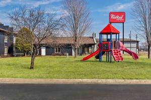 a playground with a slide in front of a cocacola sign at Red Roof Inn & Suites Tomah in Tomah