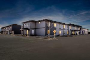 a row of buildings in a parking lot at Red Roof Inn & Suites Tomah in Tomah