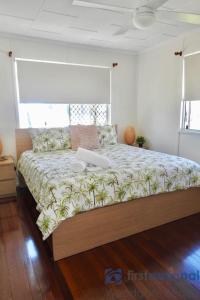a bedroom with a large bed with a laptop on it at 58 The Esplanade in Woodgate