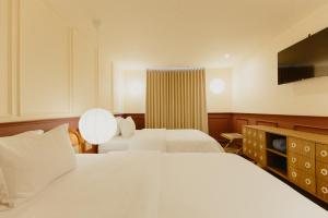 a hotel room with two beds and a flat screen tv at Hotel Belisario in Medellín