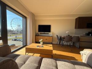 a living room with a couch and a large window at Nameja Apartamenti in Riga