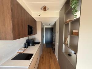 a kitchen with white counter tops and wooden cabinets at Nameja Apartamenti in Riga