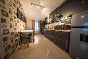 a kitchen with a refrigerator and a table in it at Complex Rediu 54 Luxury Apartaments in Iaşi
