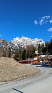 an empty road with a snow covered mountain in the background at Hotel Villa Ines in Borca di Cadore