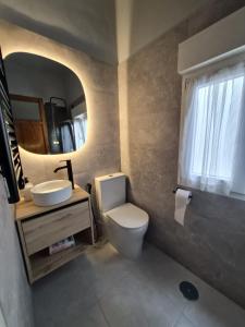 a bathroom with a toilet and a sink and a mirror at Espacio Yina Grado in Grado