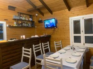 a dining room with a table and chairs and a television at Bujtina Shpella e Plakës Çerçan in Librazhd +43 photos