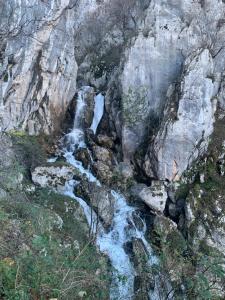an aerial view of a waterfall on a rocky mountain at Bujtina Shpella e Plakës Çerçan in Librazhd