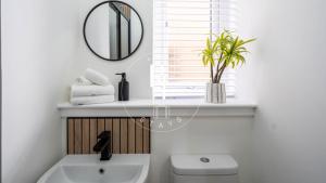 a bathroom with a sink and a mirror and a toilet at The Den at Abernethy in Peterhead