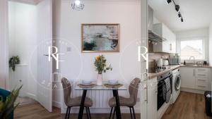a kitchen with a small table and chairs in a room at The Den at Abernethy in Peterhead