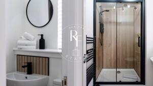 a bathroom with a shower and a sink and a mirror at The Den at Abernethy in Peterhead