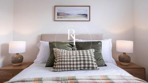 a bedroom with a bed with a r sign on it at The Den at Abernethy in Peterhead