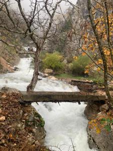 a bridge over a river with snow on it at Bujtina Shpella e Plakës Çerçan in Librazhd