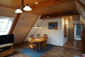 a dining room with a table and chairs and a tv at Nordseerex in Ahrenshöft