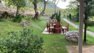 a garden with a table and chairs in the grass at Bujtina Shpella e Plakës Çerçan in Librazhd