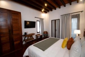 a bedroom with a bed and a desk and a television at Mirtala Hotel Boutique in Guanajuato