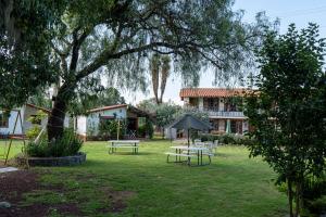 a yard with picnic tables and a house at Hotel La Casona Real in Huasca de Ocampo