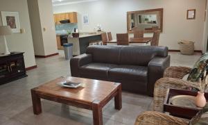 a living room with a leather couch and a table at A22SelborneGolfEstatePennington in Pennington