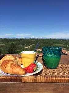 a table with a plate of bread and a cup of juice at La Mela Antica in Cherasco