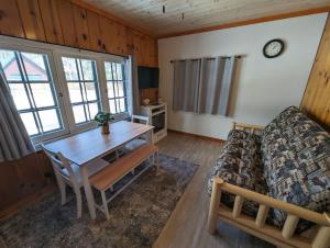a living room with a table and a couch at 2BR 1BA Cabin #3 Riverside Point Resort in Park Rapids