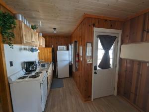 a kitchen with white appliances and a white refrigerator at 2BR 1BA Cabin #3 Riverside Point Resort in Park Rapids