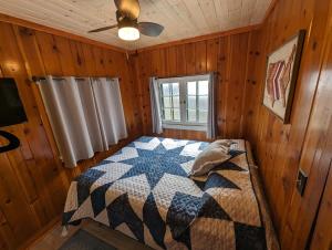a bedroom with a bed in a wooden room at 2BR 1BA Cabin #3 Riverside Point Resort in Park Rapids +57 photos