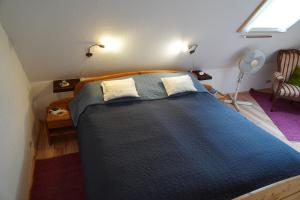 a bedroom with a blue bed with two pillows at Nordseerex in Ahrenshöft
