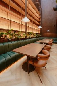 a row of tables in a restaurant with plants at Hotel Belisario in Medellín