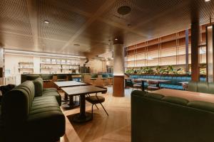 a restaurant with couches and a table and chairs at Hotel Belisario in Medellín