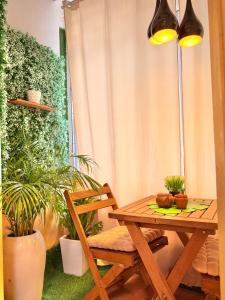a wooden table and chair in a room with plants at Cozy & Secure 1BR Apartment in Central Luanda in Luanda