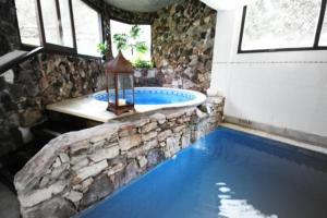 a large swimming pool with a tub in a room at Villa Ostende Apart Hotel & Spa in Ostende
