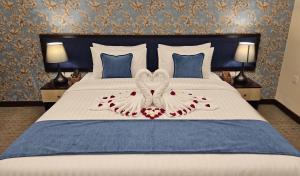 ein Schlafzimmer mit einem weißen Bett mit zwei Herzen in der Unterkunft Twilight Hotel Al-Hail in Muscat + 21 Fotos