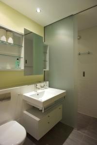 a bathroom with a white sink and a toilet at Appartement im Park in Minusio