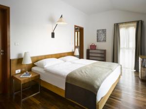 a bedroom with a large white bed and a night stand at Private luxury Villa BIANCO on Solta for up to 10 persons, heated pool, free parking, very close to the beach! FREE Kajak & Mountainbikes, GREAT living area & privacy! in Rogač
