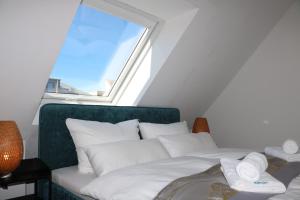 a bed with white pillows in a room with a window at Altstadt Suites am Kamp, Parkhaus möglich in Paderborn