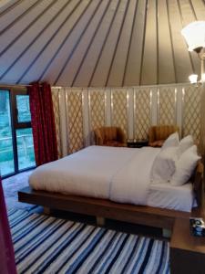 a large bed in a room with a tent at Moksha Resort Hunza in Chamangul +3 photos