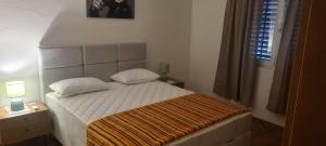 a small bedroom with a bed with white sheets and a window at Batea 1 in Seline