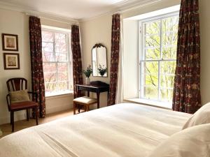 a bedroom with a bed and a desk and a window at The Coach House in Stirling
