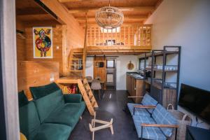 a living room with two green couches and a television at Holiday Home Maridu Tiny Cube in Arnhem