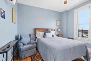 a bedroom with a bed and a chair and a window at The Tiptonian in Tipton
