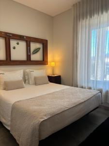a bedroom with a large white bed with a window at Quinchoso dos Bentos in Vila Pouca de Aguiar +70 photos