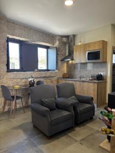 a living room with a couch and a kitchen at Quinchoso dos Bentos in Vila Pouca de Aguiar