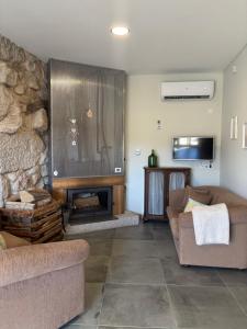 a living room with two couches and a fireplace at Quinchoso dos Bentos in Vila Pouca de Aguiar