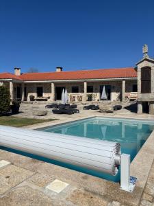 a swimming pool in front of a building at Quinchoso dos Bentos in Vila Pouca de Aguiar