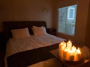 a bedroom with a bed with candles on a table at Wot Luxury Gold Center in Arad