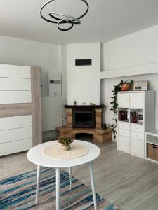 a living room with a white table and a fireplace at Vecpilsētas apartaments in Cēsis