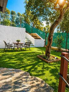 a park with two benches and a table and a tree at Green House in Llagostera